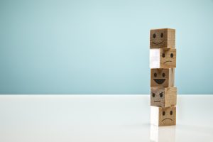 Blocks with different faces on Blue Background symbolizing emotions and complicated life
